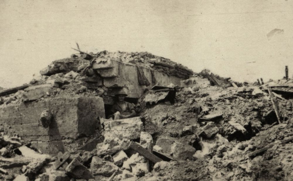 An Allied soldier stands inside a partially destroyed German pillbox, Messines.